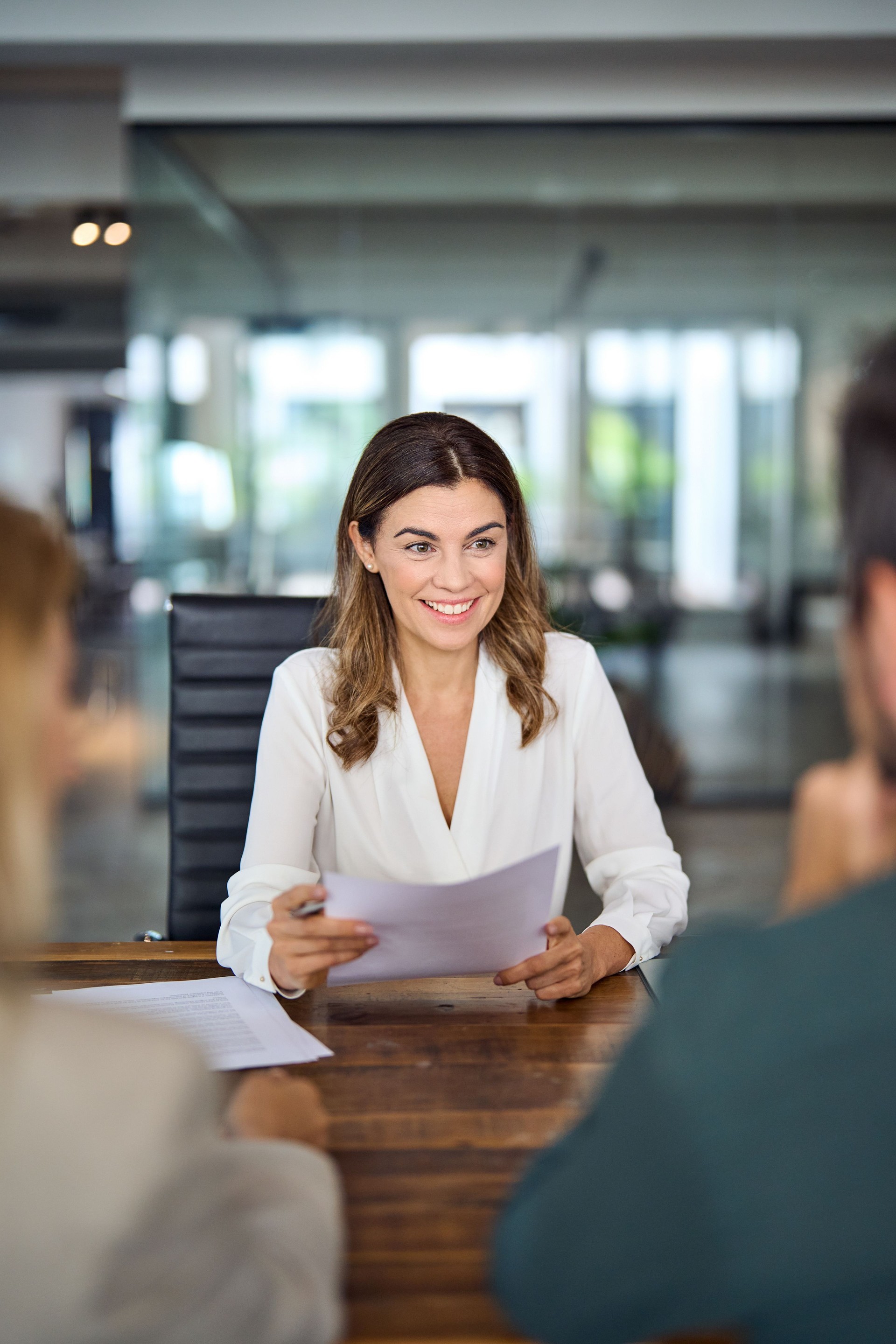 Happy business woman bank manager consulting client at office meeting. Vertical